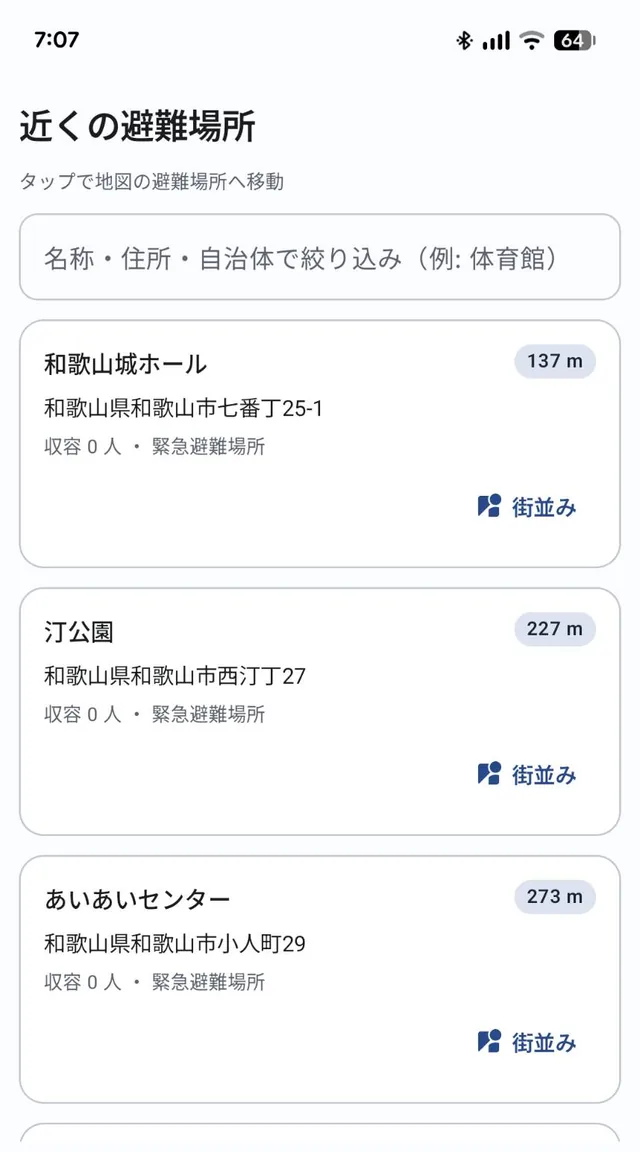 近くの避難場所の一覧画面。名称・住所・自治体での絞り込み欄と、距離の近い順に並んだ緊急避難場所の名称・住所・距離が表示されている